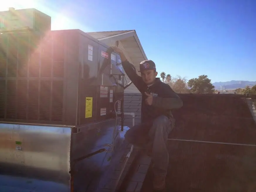 HVAC technician performing AC Tune-Up on a rooftop unit in Royalton
